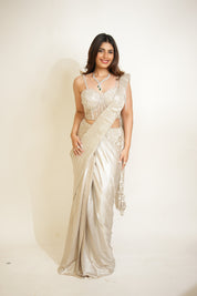 Woman wearing a silver saree with a white background
