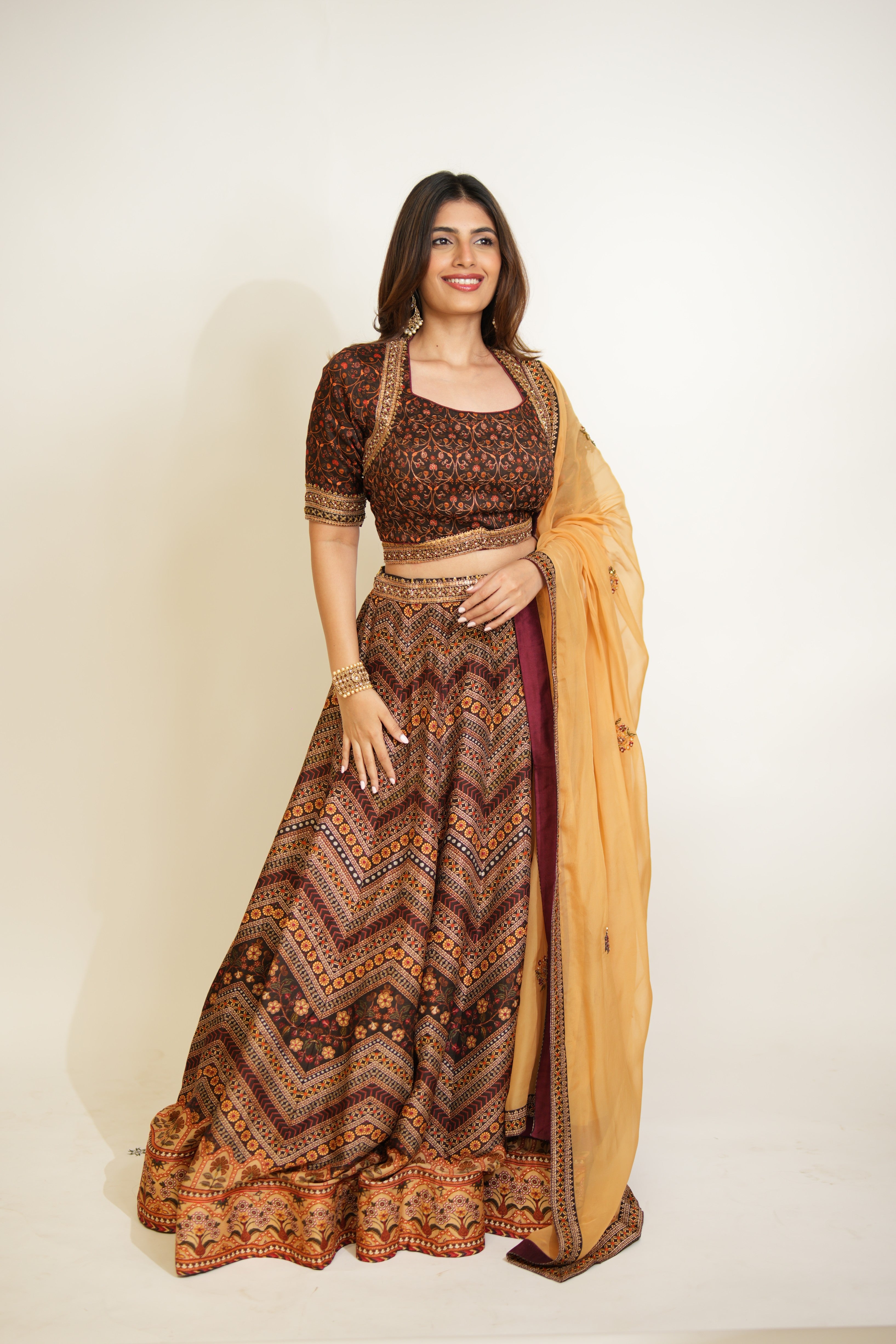 Woman wearing a traditional patterned outfit with a yellow dupatta on a white background