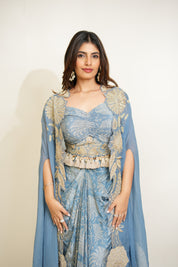 Woman wearing a blue and gold traditional outfit with a plain background
