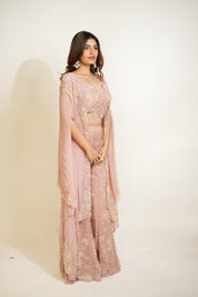 Woman wearing a pink saree with a matching blouse on a white background