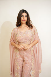 Woman wearing a pink traditional outfit with a sheer dupatta against a white background