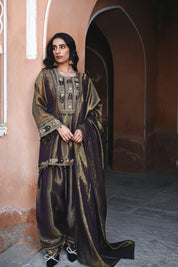 Woman in an ornate traditional outfit standing in a historic architectural setting.
