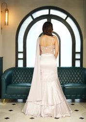 Woman in a lavendar mist evening indo western standing in a stylish interior setting.
